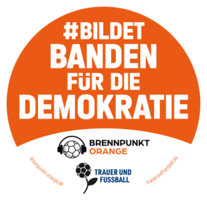 Ein oranger Sticker mit dem Text #BildetBandenFürDieDemokratie von "Brennpunkt Orange" und "Trauer und Fußball".